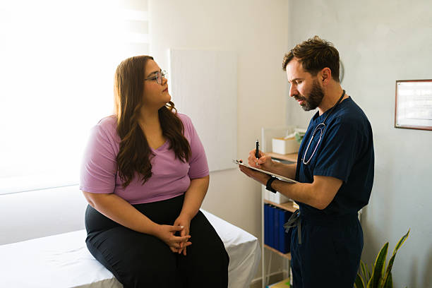 plus size female patient conversing with healthcare professional taking notes during medical2205627262