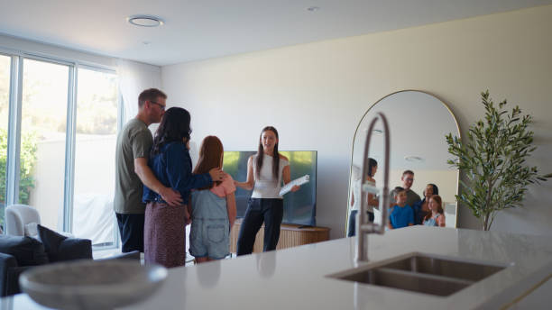 real estate agent explaining home features to a family in the living room2197589614